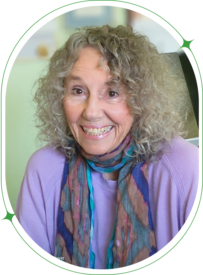 A woman with curly hair wearing a purple shirt and scarf.